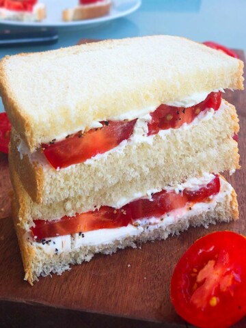 Stack of Fresh Tomato Sandwiches on a Wood Board