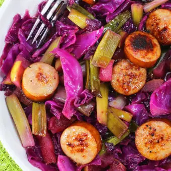 Easy Homemade Sausage and Cabbage in White Bowl on Green Background