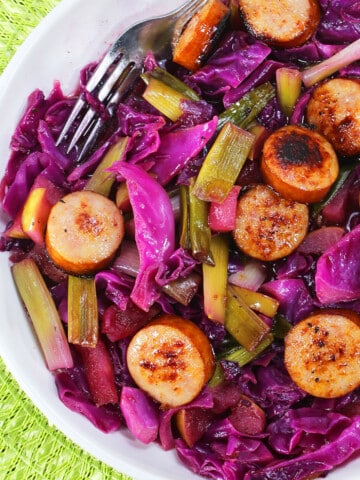 Easy Homemade Sausage and Cabbage in White Bowl on Green Background