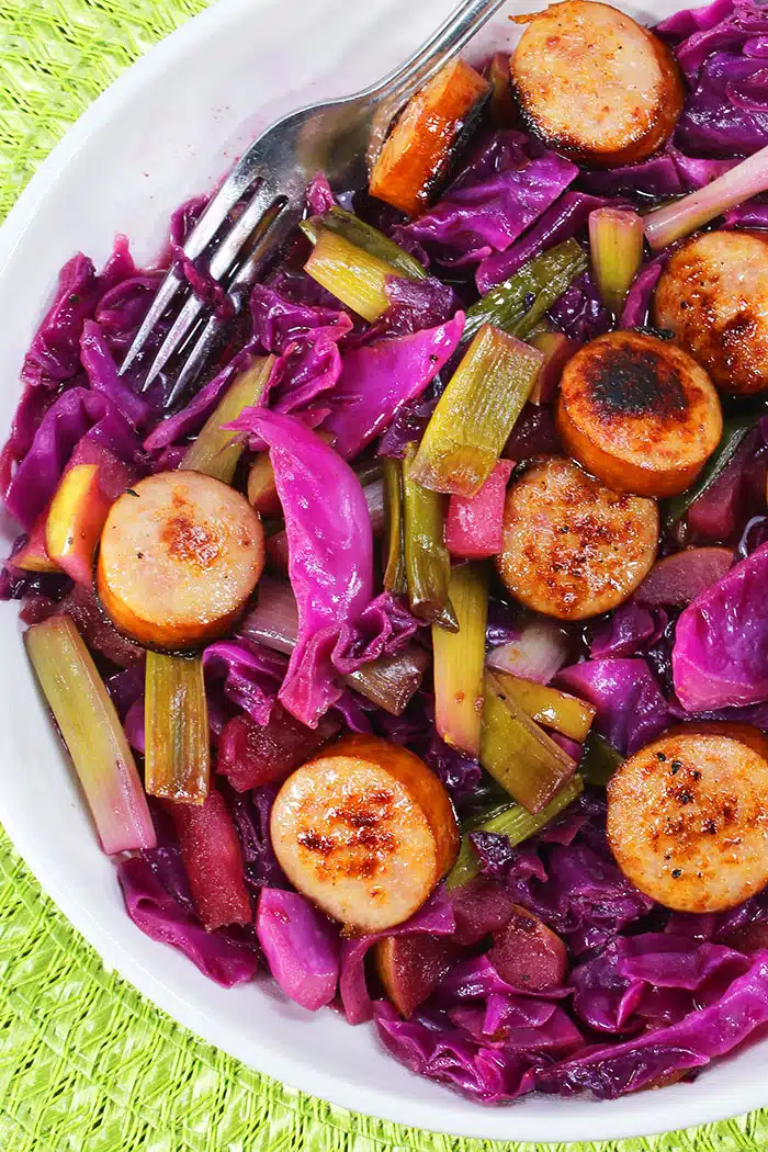 Easy Homemade Sausage and Cabbage in White Bowl on Green Background