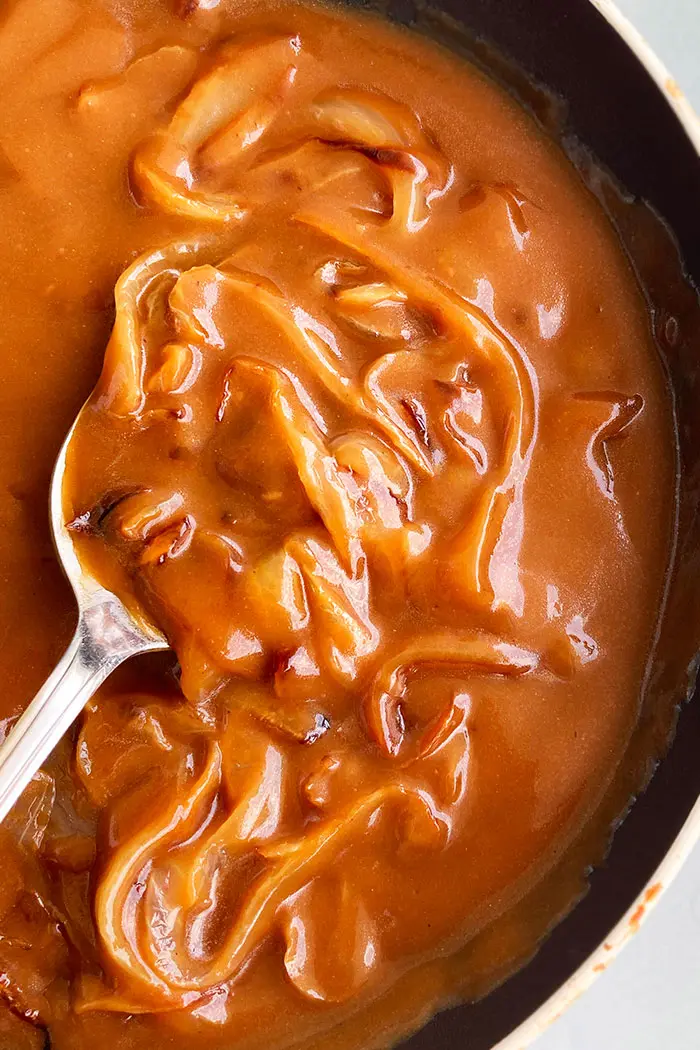 Overhead Shot of Onion Gravy in Black Pot