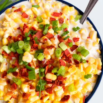 Easy Homemade Creamed Corn in Dark Blue Bowl on White Background