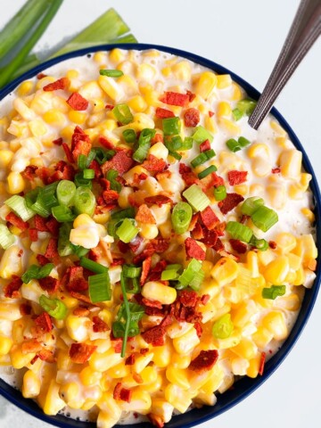 Easy Homemade Creamed Corn in Dark Blue Bowl on White Background