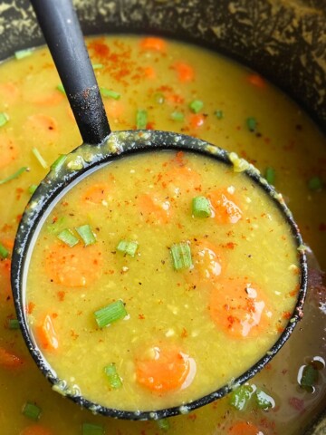 Spoonful of Split Pea Soup with Ham Bone in Black Pot