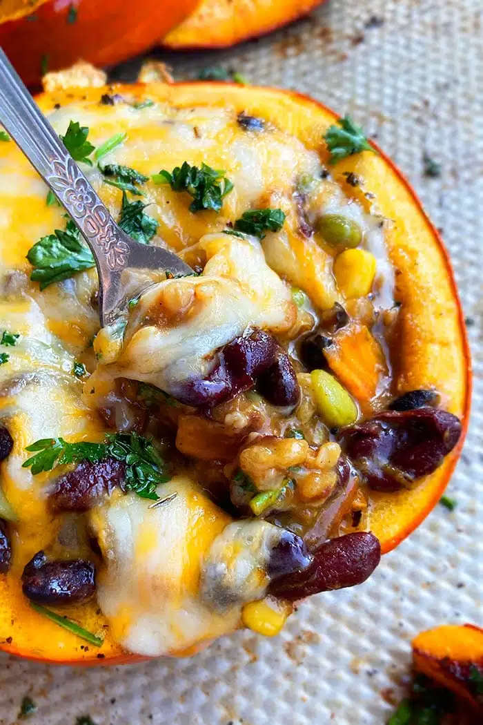 Closeup Shot of Spoonful of Cheesy Chili Filling Inside Roasted Pumpkin