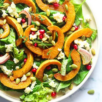 Homemade Roasted Pumpkin Salad with Feta Cheese on White Plate- Overhead Shot