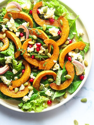 Homemade Roasted Pumpkin Salad with Feta Cheese on White Plate- Overhead Shot