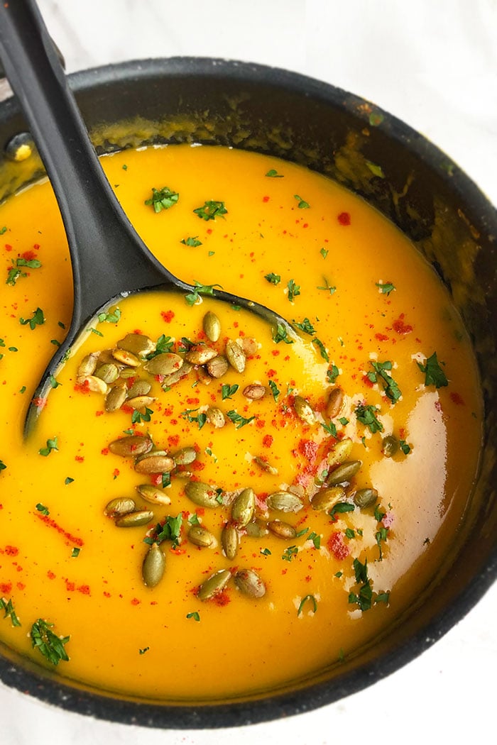 Easy Curried Butternut Squash Soup in Black Pot With Pumpkin Seed Garnish