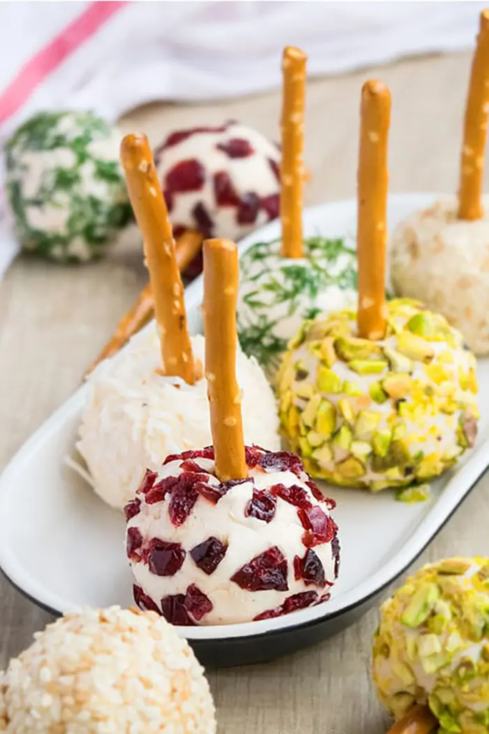 Platter of Variety of Mini Cheese Balls on White Plate on Wood Surface