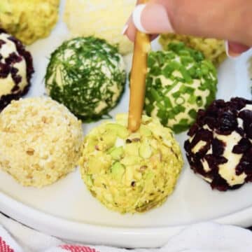 Mini pretzel stick being pushed into savory balls. 