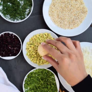 Savory ball being rolled in various toppings. 