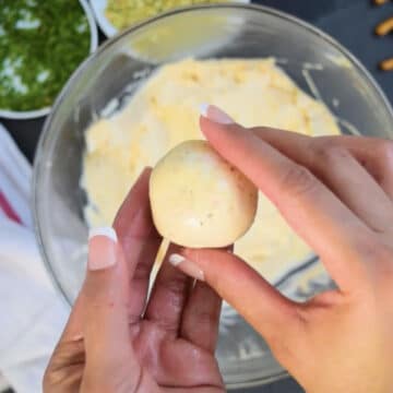 Mixture being rolled into a small ball. 