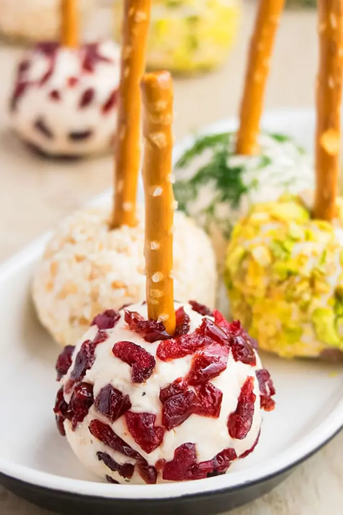 Mini Cheese Ball Bites with Dried Cranberries in White Plate on Wood Surface