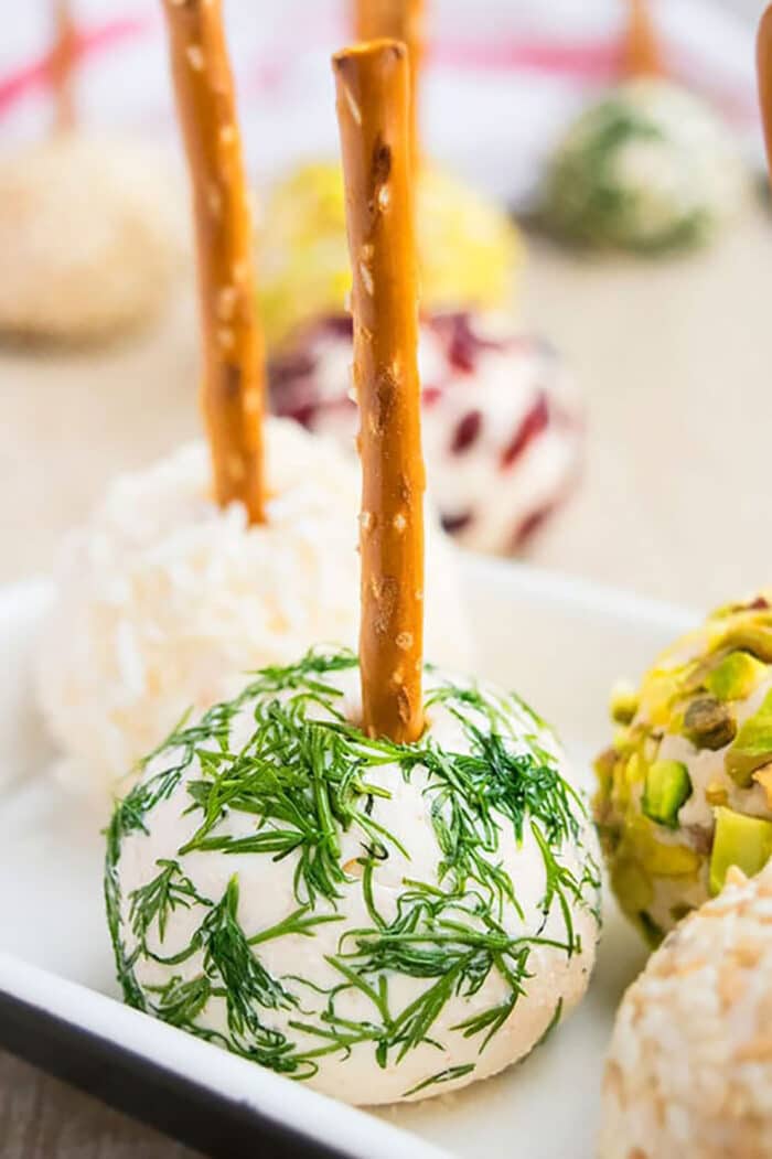 Easy Homemade Mini Cream Cheese Appetizer with Pretzel Stick and Covered in Dill on White Dish. 
