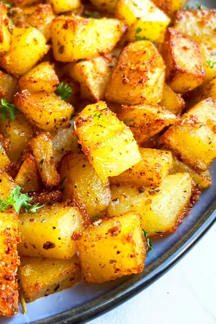 Best Roasted Homemade Seasoned Potatoes For Breakfast in Navy Blue Plate- Angled Shot