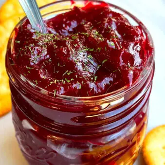 Easy Homemade Cranberry Chutney In Glass Jar on White Marble Background