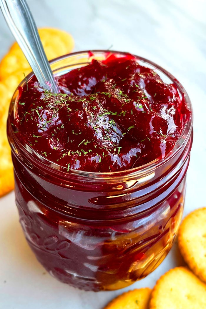 Easy Homemade Cranberry Chutney In Glass Jar on White Marble Background