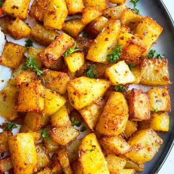 Easy Crispy Oven Baked Breakfast Potatoes in Navy Blue Plate on White Background