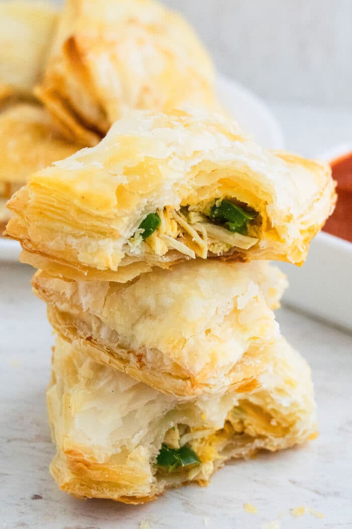 Stack of Easy Chicken Puff Pastry with Partial Bite on Top Puff.