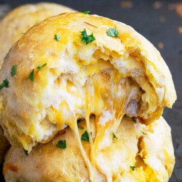 Stack of One Pan Stuffed Garlic Cheese Bombs With Cheese Melting Out.