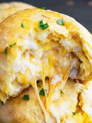 Stack of One Pan Stuffed Garlic Cheese Bombs With Cheese Melting Out.