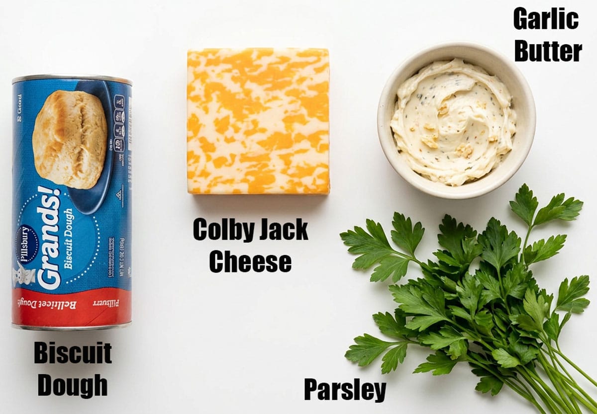 Ingredients for recipe on white background- biscuit dough, cheese, parsley, butter.