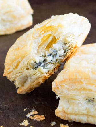 Easy Spinach Puffs With Partial Bite Removed on Black Tray