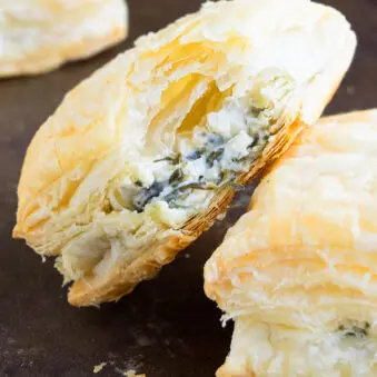 Easy Spinach Puffs With Partial Bite Removed on Black Tray