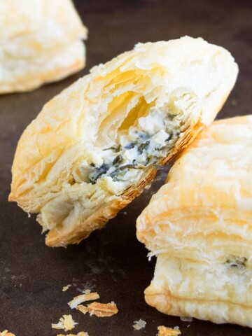 Easy Spinach Puffs With Partial Bite Removed on Black Tray