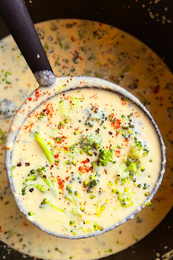 Closeup Shot of Spoonful of Broccoli and Cheese Soup in Black Pot