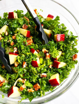 Easy Massaged Kale Salad in Glass Bowl With Tongs- Overhead Shot