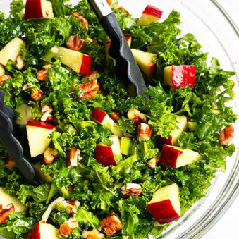 Easy Massaged Kale Salad in Glass Bowl With Tongs- Overhead Shot