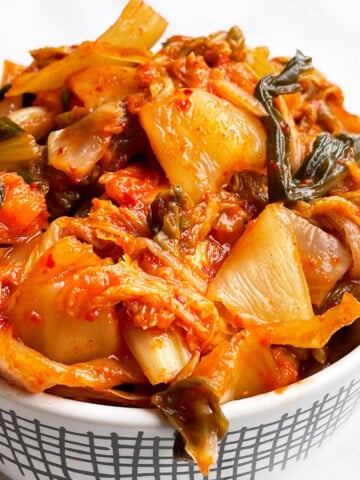 Best Easy Homemade Korean Kimchi Cabbage in White Bowl on White Background.