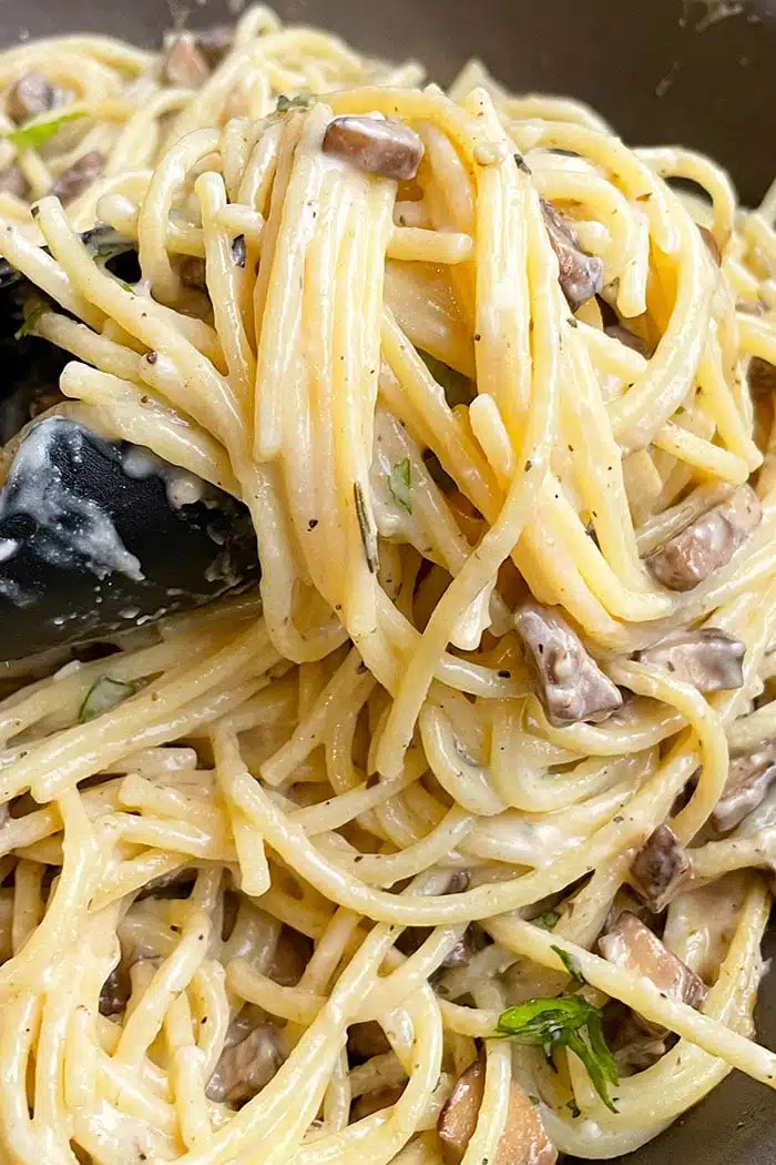 Closeup Shot of Tongs Full of Easy Spaghetti With Cheesy Mushroom Pasta Sauce 