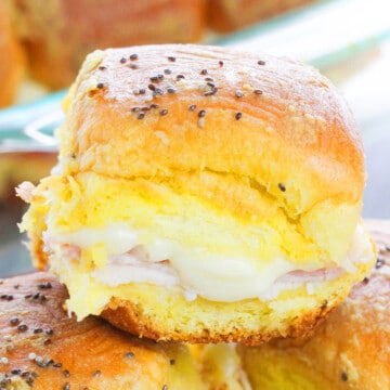 Closeup Shot of Easy Ham and Cheese Sliders With Garlic Butter Stacked on One Another in a Plate.