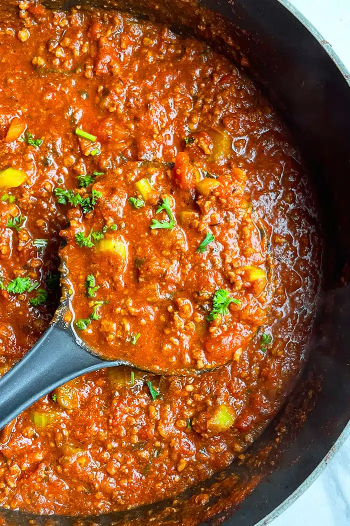 Easy Homemade Instant Pot Bolognese Sauce in Black Pot on White Background