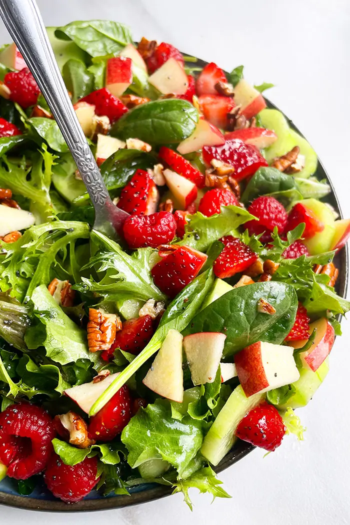 Easy Summer Salad in Black Plate With Fork on White Background