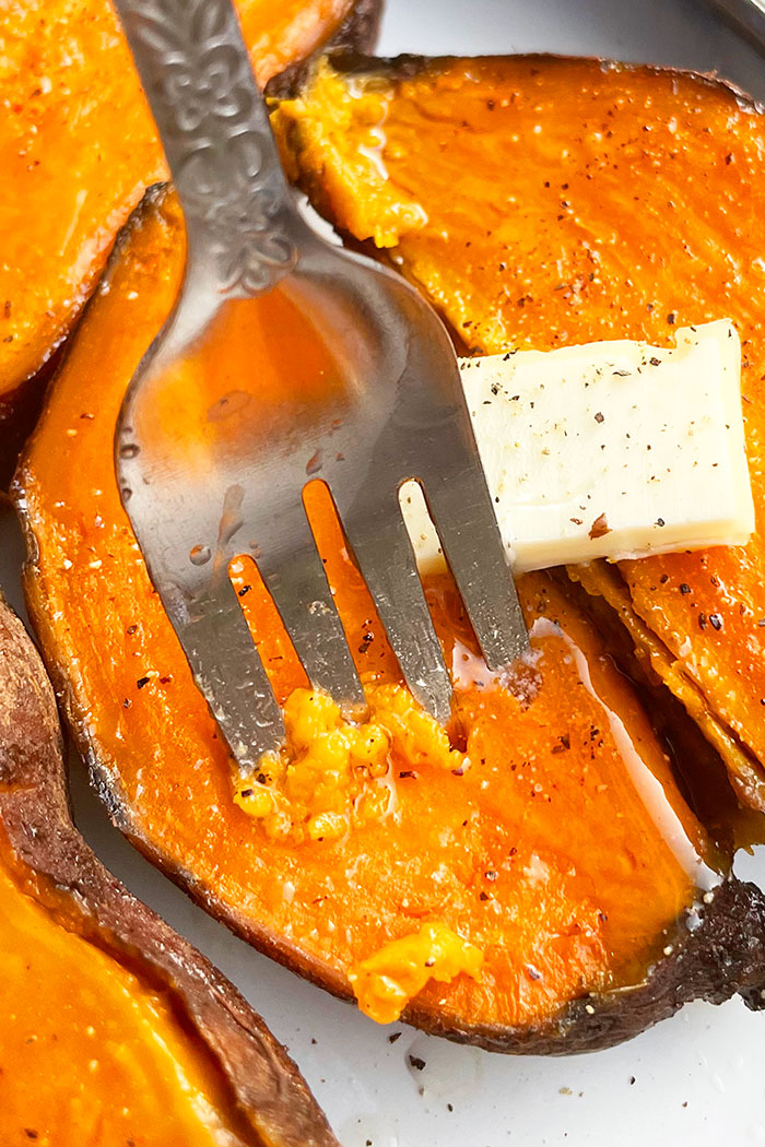 Fork Full of Tender Sweet Potato Flesh With Butter, Salt and Pepper- Closeup Shot