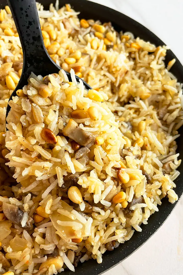 Spoonful of Mushroom Rice Pilaf in Black Pot- Closeup Shot