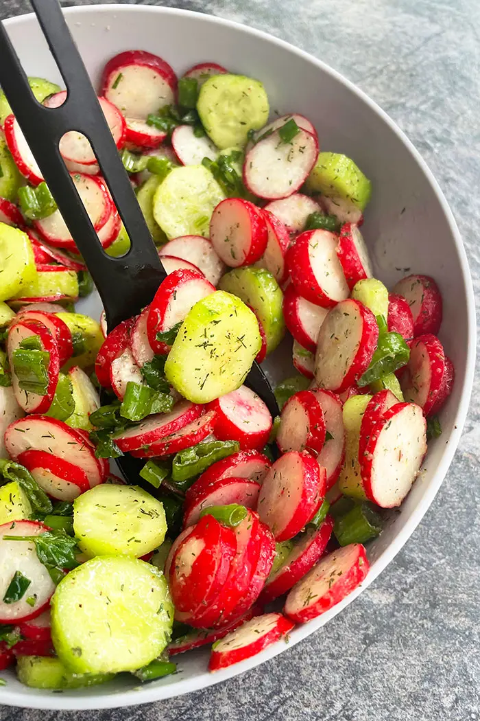 Homemade Healthy Salad With Light Lemon Dressing in Gray Bowl on Rustic Gray Background- Angled Shot