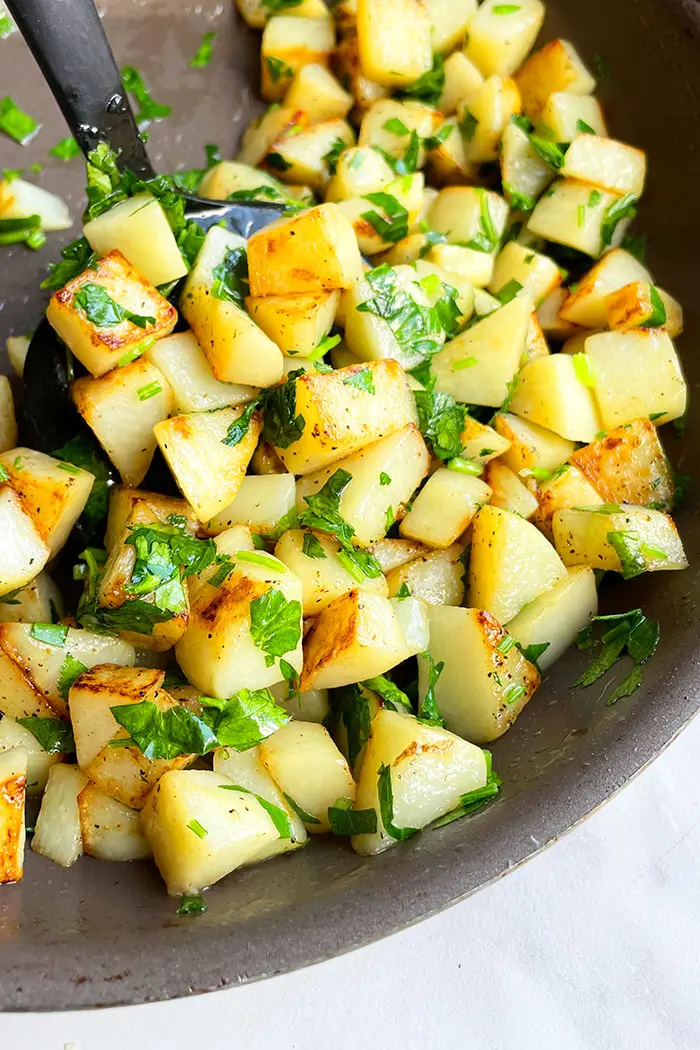 Old Fashioned Buttered Potatoes in Black Pot With White Background