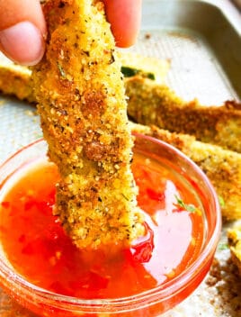 Easy Homemade Crispy Zucchini Fries (Courgette Fries) Being Dipped in a Bowl of Sweet and Spicy Sauce