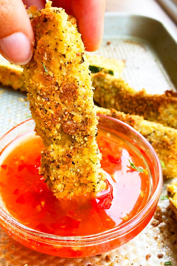 Easy Homemade Crispy Zucchini Fries Being Dipped in a Bowl of Sweet and Spicy Sauce