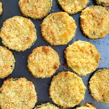 Golden brown zucchini slices on baking tray.