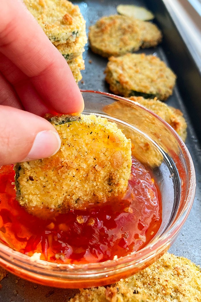 Zucchini Crisps Being Dipped in Sweet and Spicy Sauce