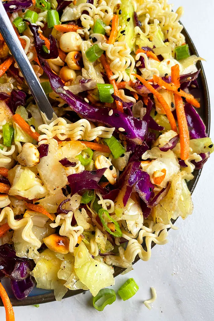 Spoonful of Crunchy Asian Slaw With Ramen on White Background