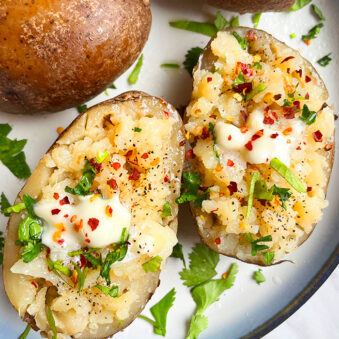 Easy Fluffy Microwave Baked Potatoes With Lots of Toppings in White Plate