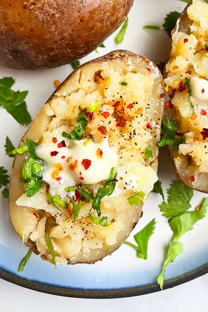 Microwave Potato With Various Toppings On White Plate- Overhead Shot