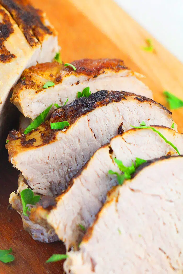 Closeup Shot of a Slice of Tender Pork Loin on Wood Background