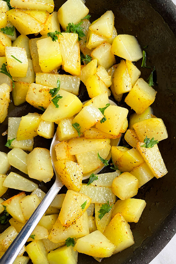 Easy Crispy Sauteed Potatoes With Garlic and Lemon Pepper in Black Pan- Overhead Shot 